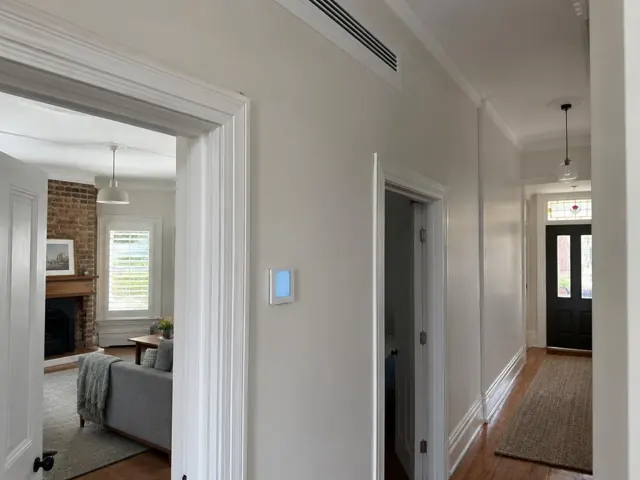 Hallway with ceiling air grille and wall controller in a home interior in Norwood